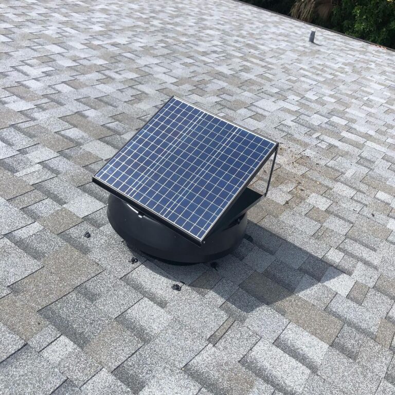 A solar attic fan is shown on a roof with grey shingles. Solar attic fans can qualify homeowners for tax rebates and incentives.
